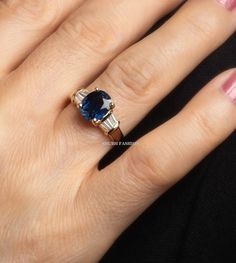 Sapphire engagement ring, Blue sapphire ring, Side Tapper diamond ring, Art Deco Ring, Blue Gemstone Statement Ring, Anniversary Gift Ring ✦ CENTER STONE DETAIL ✦ ✧ Stone Type : Lab Created ✧ Stone Shape : Oval ✧ Stone Size : 9x7 MM ✧ Stone Color : Blue Sapphire ✧ Stone Clarity: Si ✧ Luster: Excellent ✧ Make: High-Quality Craftsmanship ✦ SIDE STONE DETAIL ✦ ✧ Stone Type : Simulated Diamond ✧ Stone Shape : Tapper Baguette ✧ Stone Color : D (White High brilliant) ✧ Stone Clarity : VVS ✧ Luster: Excellent ENGRAVING IS AVAILABLE ✦ 𝐌𝐞𝐭𝐚𝐥 𝐃𝐞𝐭𝐚𝐢𝐥𝐬 ✦ ✧ Metal Type: Solid Gold , 925 Silver ✧ Metal Purity: 10K | 14K | 18K | 925 Silver ✧ Metal Tone: Rose | White | Yellow ( Selict Option in Material ) This ring can be customized by the moissanite(E-F color, VVS clarity)center Stone,please c Oval Blue Sapphire Ring For Proposal, Blue Oval Sapphire Ring For Proposal, Blue Sapphire Ring With Diamond Accents And Round Cut, Sapphire Baguette Cut Ring With Diamond Accent Stones, Blue Diamond Ring With Diamond Accents Emerald Cut, Sapphire Diamond Ring With Baguette Cut And Accent Stones, Blue Sapphire Ring With Diamond, Round Shape, Blue Emerald Cut Diamond Ring With Diamond Accents, Lab-created Sapphire Baguette Cut Ring For Wedding