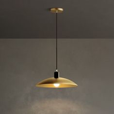 a light that is hanging from a ceiling in a room with gray walls and flooring