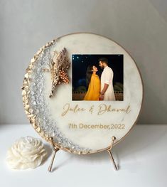 a wedding cake with a photo on it and a white flower next to the cake