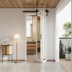 an open door leading to a bathroom with a table and lamp in the corner next to it