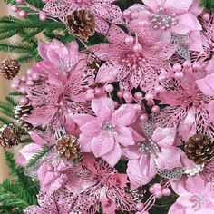 pink flowers and pine cones are arranged together