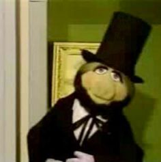 the puppet is dressed in a suit and top hat