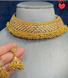 Add a touch of elegance to your attire with our stunning gold jewelry set. Indian, Bollywood style jewelry and includes a choker necklace and matching earrings. While the set might be considered a statement piece in western fashion, it is a rather minimalist set in Indian traditions. This beautiful set features a wide choker necklace and Jhumkis-inspired earrings, both adorned with delicate dangling pearls in gold. The whole jewelry is covered in yellow gold, giving a classic and elegant finish.  Gold is a timeless piece of jewelry, and this set will look elegant no matter the occasion. The gold jewelry can be paired with western and Indian attire, matched with a festival, evening party dress, saree, salwar suit, lenga, and more. Buy it for yourself or gift it, and makes a special gift to Elegant Gold Lehenga With Intricate Design, Gold Bridal Sets With Meenakari For Reception, Gold Bridal Sets With Cutdana For Reception, Elegant Lehenga With Pallu As A Gift, Gold Cutdana Jewelry Sets For Reception, Diwali Gold Lehenga With Intricate Design, Gold Plated Kundan Necklace With Latkans For Wedding, Gold Plated Bridal Necklace With Latkans For Wedding, Gold Hand-set Lehenga For Reception