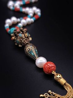 Description and Details  Discover the beautiful Tibetan jewelry masterpiece that represents a blend of traditional and modern elements in this One-of-a-kind Deluxe long necklace!  Freshwater Pearls, Coral, and Turquoise are designed to enhance the beauty of the handmade Tibetan pendant featured in the necklace.  One-of-a-kind  Item: E 450 Freshwater Pearl  Turquoise  Tibetan Silver, Turquoise  Carved Copal Tassel: Vermeil  Clasp: Vermeil  Approx. 29" Silk hand-knotted Elegant 108 Beads Jewelry Gift, Elegant Necklace With 108 Beads For Gift, Elegant Multicolor Necklaces For Ceremonial Occasions, Elegant Necklace With 108 Beads Pendant, Spiritual Long Necklace With Gemstone Beads As A Gift, Luxury Gemstone Pearl Necklace, Traditional Hand-strung Necklaces As Gifts, Unique Long Necklace With Round Beads For Gift, Artisan Hand-strung Jewelry For Ceremonial Occasions