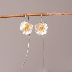 These Poppy Flower Drop Earrings, crafted from premium 925 silver, are an homage to the subtle power of nature's artistry. With petals that display a lifelike texture and a center delicately brushed with gold, they capture the wild and free essence of poppies in bloom. Lightweight and with a gentle sway, they offer a whisper of movement, a dash of sophistication to your daily wear or a statement piece for special occasions. Let these earrings be a symbol of resilience and beauty, mirroring the e Sterling Silver Adjustable Drop Flower Earrings, Adjustable Sterling Silver Drop Flower Earrings, White Sterling Silver Pierced Flower Earrings, Sterling Silver Birth Flower Drop Earrings, Adjustable Sterling Silver Flower Earrings, Sterling Silver Earrings With Birth Flower Detail, Sterling Silver White Birth Flower Earrings, Sterling Silver Birth Flower Earrings In Silver, Nature-inspired Flower Sterling Silver Earrings