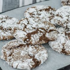 chocolate crinkle cookies with powdered sugar on top sitting on a baking sheet