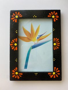 a black frame with an orange flower on it