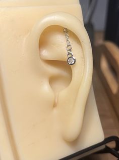 a pair of earrings sitting on top of a piece of wax