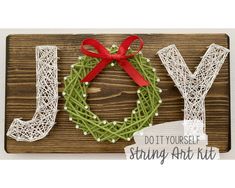 a string art kit with the word joy written in it and a red bow on top