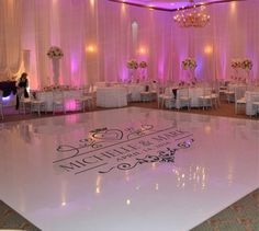 the dance floor is decorated with white chairs and chandeliers