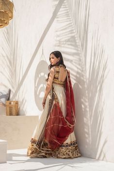 Turn heads in this ivory Khaddi silk peshwas with printed border and embellished neckline. The gota finished worked jacket. It is paired with a worked gota jacket in signature geometric pattern and a burgundy coloured printed organza dupatta that is finished with gota detailing. Bohemian Anarkali Set With Zari Work For Transitional Season, Transitional Bohemian Anarkali Set With Zari Work, Traditional Cotton Silk Nehru Jacket With Cutdana, Traditional Nehru Jacket In Cotton Silk With Cutdana, Cream Silk Anarkali Set, Traditional Nehru Jacket With Cutdana In Cotton Silk, Festive Off-white Embroidered Sharara, Festive White Nehru Jacket With Mirror Work, Bohemian Off White Chanderi Kurta