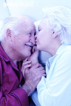 an older man and woman kissing each other