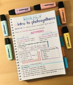 a notebook with writing on it next to markers and pens