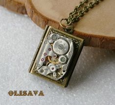 "Steampunk Jewelry - pendant with Antique Mechanical Jeweled Watch Movement , book  pendant . Here is a  steampunk book style bronze plated locket necklace . The locket opens out to reveal two sections for photos.  The size is book pendant  3/4\" X  7/8 \" and it has a 21\" bronze plated  chain . More Steampunk jewelry are here: https://www.etsy.com/shop/Olisava?section_id=14708491" Punk Journal, Steampunk Book, Book Pendant, Steampunk Accessories, Book Style, Steampunk Jewelry, Jewelry Pendant, Watch Movement, Locket Necklace