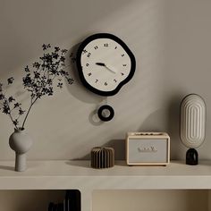 there is a clock on the wall next to a radio and vase with flowers in it