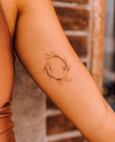 a woman's arm with a tattoo on it that has a fish in the middle