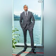 a man in a suit standing next to a window