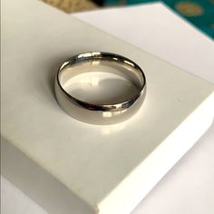 a silver ring sitting on top of a white box