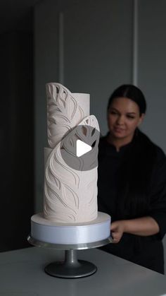 a woman standing in front of a white cake