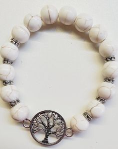 Stone Tree Of Life Beaded Stretch Bracelet This Stone Tree Of Life Beaded Stretch Bracelet features a silver tree of life charm adorned with stone beads in a variety of colors, including black, white, red, and turquoise. Your choice of color White Round Bohemian Stretch Bracelet, White Bohemian Stretch Bracelet, Bohemian Charm Bracelet With White Round Beads, Bohemian White Charm Bracelet With Round Beads, Spiritual White Beaded Charm Bracelet, White Natural Stones Round Beads, White Round Natural Stone Beads, Bohemian White Round Crystal Bracelet, White Howlite Bohemian Bracelets