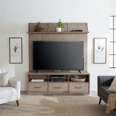 a living room with a couch, chair and television on top of the entertainment center