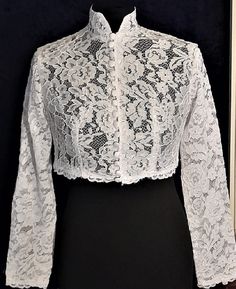 Perfect for when you want to have the look of sleeves without the commitment of actually having sleeves, the Lace Bolero is a wonderfully classic accessory for you to wear over all sorts of sleeveless tops and dresses! Made from high quality fabric, this beautiful lace jacket possesses a floral pattern in the lace. It has a button closure at the front. Add a comfortable, breathable layer to your outfit when you accessorize with the Lace Bolero and be the envy of any fan of the classic style! Size: S,M,L,XL,XXL Size S fits 39cm shoulders and 86cm bust, back length is 37.5cm. Size M fits 40cm shoulders and 91cm bust,back length is 38cm. Size L  fits 41 cm shoulders and 96cm bust,back length is 38.5cm. Size XL fits 42cm shoulders and 101cm bust,back length is 39cm. Size XXL fits 43cm shoulder Fitted White Outerwear For Ceremony, White Fitted Ceremony Outerwear, Elegant White Lace Outerwear, White Long Sleeve Outerwear For Ceremony, Vintage Fitted Outerwear For Wedding, Elegant Long Sleeve Outerwear For Ceremony, Classic White Wedding Outerwear, Long Sleeve Shrug For Spring Weddings, Fitted Lace Outerwear For Wedding