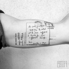 a person's arm with a handwritten letter and envelope tattoo on the left forearm