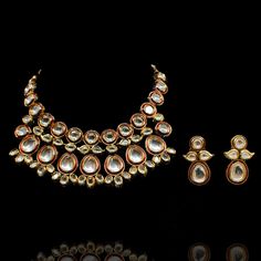 A dreamy set merging traditional with contemporary! Exude glamour in this trendy set encrusted with kundan stones over an enameled base. The look includes necklace and a pair of matching earrings. Approximate earrings length is 1.5". Gold-plated on high-quality brass as base metal. Made by order. Kindly allow 4-6 weeks for the delivery of this item. For custom or urgent requests, please contact support@alacouture.com. *Please Note: We use faux stones and beads in all of our jewelry. Formal Jewelry Sets Chandbali With Meenakari, Formal Jewelry Sets With Meenakari And Chandbali Shape, Formal Chandbali Kundan Necklace With Meenakari, Dual-tone Kundan Temple Jewelry Sets, Dual-tone Kundan Jewelry, Gold Meenakari Jewelry For Designer Wear, Festive Kundan Bridal Necklace With Matching Earrings, Festive Dual-tone Kundan Jewelry Sets, Gold Meenakari Necklace For Designer Wear