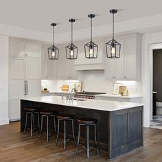 a large kitchen with white cabinets and wooden floors