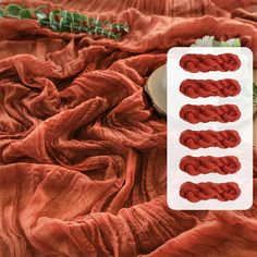 there are three pieces of red yarn on the bed sheet and one piece of white paper