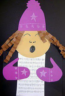 a child's paper cut out of a woman wearing a pink hat and scarf