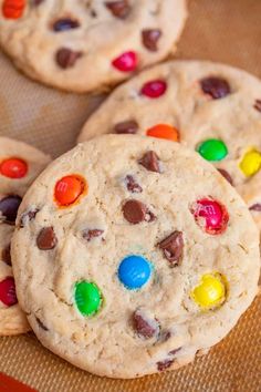 cookies with m & m's and chocolate chips are on a baking sheet, ready to be eaten