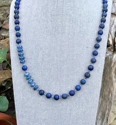 This necklace is matte lapis lazuli of varied shades of medium to dark blues, spaced with softly shaded blue sodalite and  accented with a segment of beautiful blue kyanite. 24 inches in length this necklace easily slides over your head without a clasp. Lapis Lazuli - is a protective gemstone said to help relieve stress and bring deep peace. Said to alleviate pain, especially headaches  Kyanite - is said to stimulate intuition and help to speak one's truth. Sodalite - is one of the stones that h Blue Kyanite Gemstone Bead Necklaces, Blue Kyanite Gemstone Beaded Necklace, Blue Kyanite Gemstone Necklace, Handmade Blue Sodalite Necklaces, Blue Kyanite Gemstone Beads Jewelry, Blue Kyanite Jewelry With Gemstone Beads, Blue Apatite Round Bead Necklaces, Blue Apatite Spiritual Necklace, Blue Lapis Lazuli Crystal Necklaces With Faceted Beads