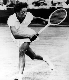 a man swinging a tennis racquet on top of a tennis court in front of an audience