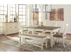 a dining room table with chairs and a bench in front of the window that has french country inspired decor on it