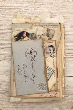 an old book with some pictures and letters on it, sitting on a wooden surface