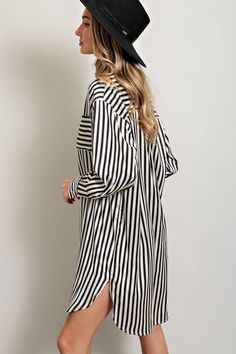 Stripe printed button down shirt dress featuring a collared neckline, one chest pocket, a high-low design, buttoned cuffs, two side slits, and a pleat in the back for added detail. Measurements: Bust: small 46", medium 48", large 50" Front Length: small 35", medium 36", large 37" Back length: small 37", medium 38", large 39" Chic Collared Shirt Dress For Day Out, Classic Collared Shirt Dress For Day Out, Long Sleeve Shirt Dress With Striped Collar For Work, Long Sleeve Shirt Dress With Striped Collar For Daywear, Striped Long Sleeve Shirt Dress For Daywear, Chic Button-up Shirt Dress With Rolled Sleeves, Classic Striped Long Sleeve Shirt Dress, Elegant Shirt Dress With Button Cuffs And Shirttail Hem, Elegant Shirt Dress With Shirttail Hem And Placket