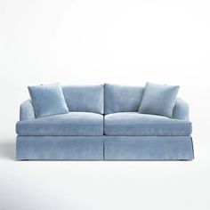 a blue couch with two pillows on the back and one arm folded out to show it's shape