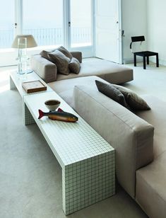 a living room filled with furniture and a fish shaped coffee table on top of it