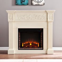 a white fireplace with two pictures above it