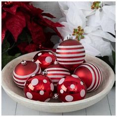 a bowl filled with red and white christmas ornaments