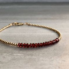 This gemstone bracelet features small genuine Garnet stones. The faceted garnet beads are a beautiful vibrant red hue. This piece is timeless, yet unique. A perfect gift for a birthday or for your Valentine. The tiny round beads frame the faceted gemstones beautifully. At checkout, choose to buy a Garnet bracelet with gold or sterling silver beads. * METAPHYSICAL PROPERTIES OF GARNETS * courage energy love passion self confidence transformation Free gift with every crystal jewelry purchase from Faceted Yellow Gold Beaded Bracelets, Yellow Gold Faceted Beaded Bracelets, Yellow Gold Beaded Bracelets With Faceted Beads As Gift, Yellow Gold Beaded Bracelet With Faceted Beads As Gift, Red Beaded Bracelet, Jewelry Bracelets Silver, Garnet Bracelet, Garnet Jewelry, Custom Bracelets