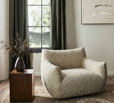 a chair sitting in front of a window next to a potted plant