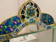 a mirror that has been decorated with blue and green designs on it's sides