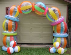 an arch made out of plastic balls in front of a garage