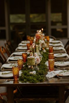 a long table is set with candles and plates