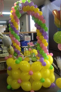 balloons are arranged in the shape of an arch on a table at a birthday party