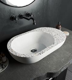 a white sink sitting on top of a counter next to a faucet and mirror