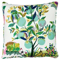 a white pillow with green and yellow floral designs on the front, featuring an apple tree