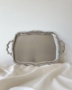 a silver tray sitting on top of a white sheet